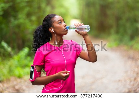 African american woman jogger drinking water  - Fitness, people and healthy lifestyle
