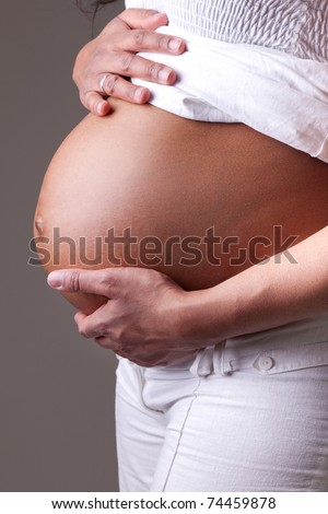 Pregnant black woman touching her belly