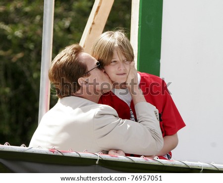 LOS ANGELES - APRIL 2: Arnold Schwarzenegger kisses his son Patrick at the softball game before the 'The Benchwarmers' movie premiere at UCLA in Los Angeles, CA on April 2, 2006