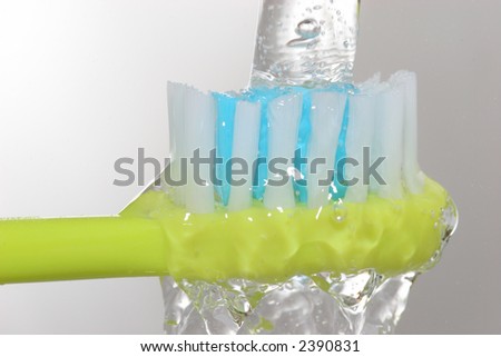 toothbrush closeup under water tap
