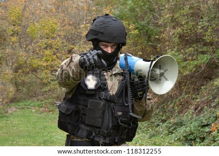 A policeman shouts orders into a megaphone
