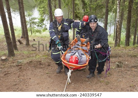 Pnovany, Czech Republic, June 4, 2014: Training rescue injured people in difficult terrain at the dam Hracholusky, carrying a stretcher with an injured person