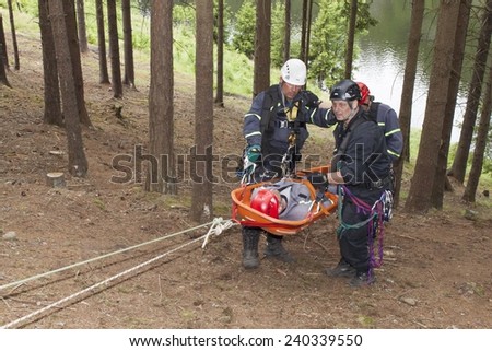 Pnovany, Czech Republic, June 4, 2014: Training rescue injured people in difficult terrain at the dam Hracholusky, carrying a stretcher with an injured person