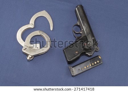 gun, magazine and police handcuffs lying on the table