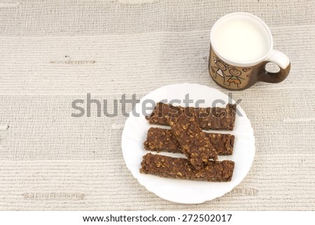 Sticks of oatmeal with chocolate, healthy breakfast with milk