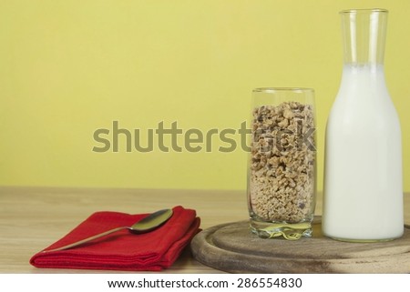 oatmeal flakes in a glassful next to the milk carafe. Healthy breakfast with fiber. Fresh milk in the glass and muesli breakfast