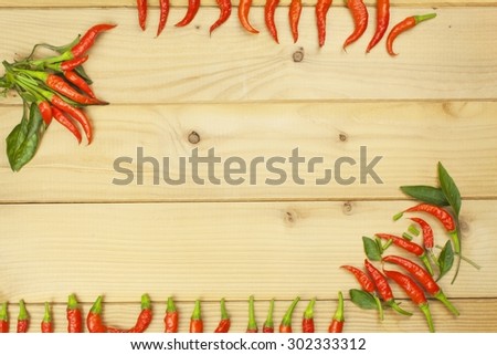 Freshly picked chili peppers on a wooden table. Preparation for the domestic processing of a crop. Decoration of chilli peppers. Place for text menu. Healthy fresh food.