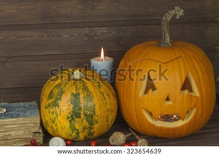 Halloween pumpkin head on wooden background. Preparing for Halloween. Head carved from a pumpkin on Halloween. Pumpkin tradition. The book of spells, magical book. Textbooks for witches.