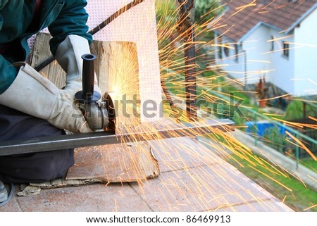 Worker outside, cut the metal rails using angle grinders