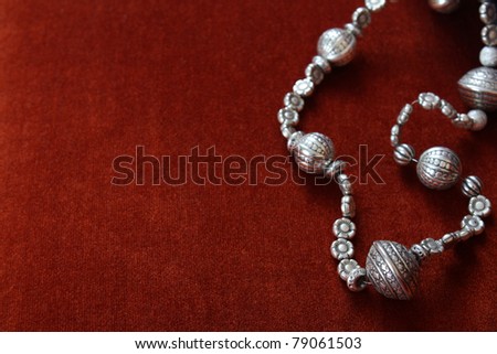 Silver bead necklace on an orange brown background