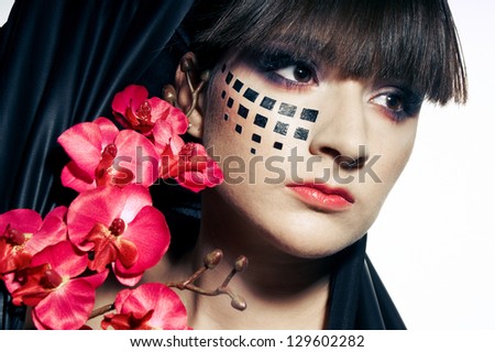 Brunette girl with black pattern on the face and red flowers