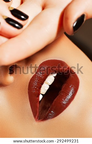 Open female mouth closeup, sensual lips with shiny lipstick, white healthy teeth