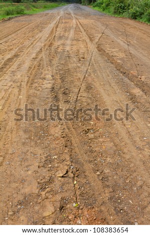 Traces of the wheels of cars and motorcycles on the roads in rural areas on the ground after a rain.