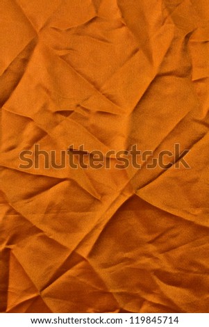 Orange fabric texture with square corners creased creases crumpled.