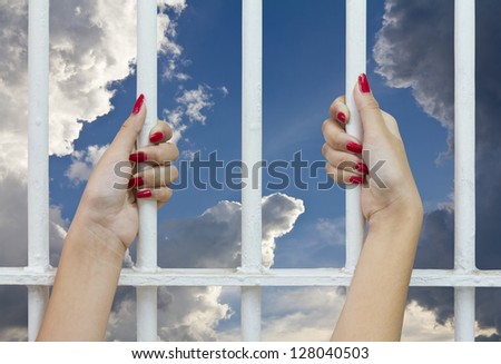 Red finger nails of women who were imprisoned in a cage, which looked out to see the sky and clouds.