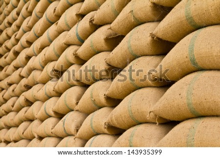Old hemp sacks containing rice placed profoundly stacked in a row to keep up.