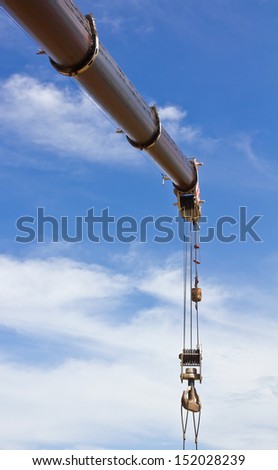 Hydraulic crane beams of large elongated heads the sky.