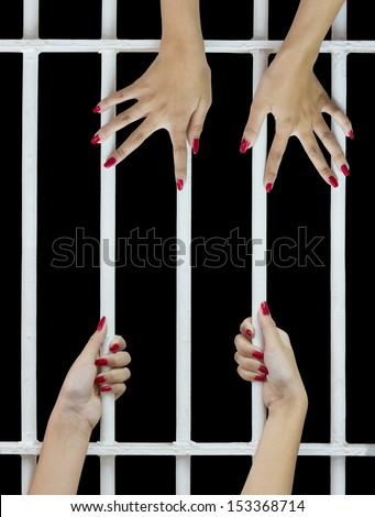 Woman fingers with red nails holding grip on the bars of the cage
