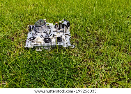 Mechanism of video tapes were discarded as trash laying on the grass.