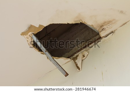 Ceiling panels damaged as a huge hole in the roof from rainwater leakage.