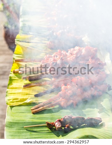 Grilled chicken, lots of smoke pollution on a banana leaf for distribution in the common market.
