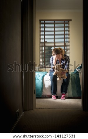 Depressed woman in her bedroom at night