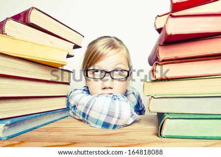 Bored child with a stack of books