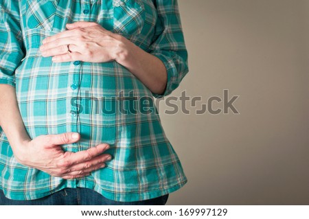 Woman holding her pregnant bump with both hands