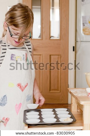 Little girl making fairy cakes