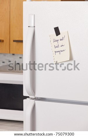 Piece of yellow paper taped to a refrigerator door
