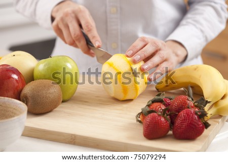 Woman in the kitchen peeling fruits