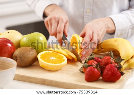 Woman in the kitchen cutting fruits