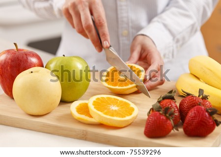 Woman in the kitchen cutting fruits