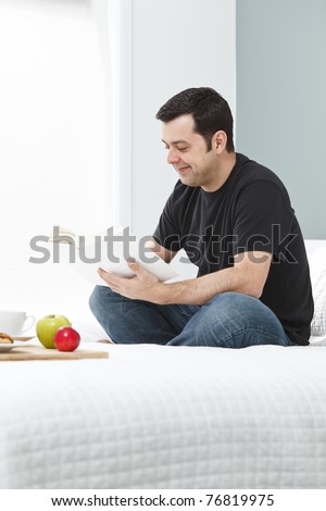 Man reading a novel in his bedroom