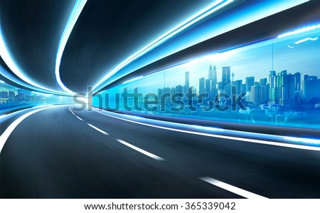 Abstract blurred speed motion road in glass tunnel over the city