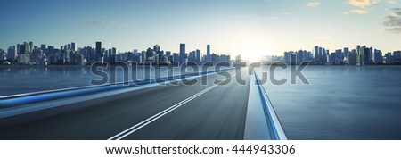 Highway overpass motion blur with city skyline background . cold mood . horizontal.
