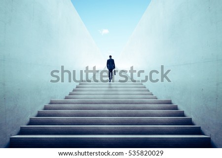 Ambitions concept with businessman climbing stairs