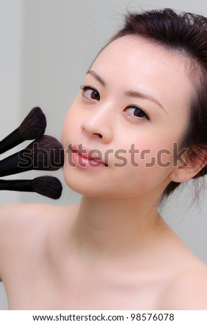 Asia girl applying makeup powder on white background,