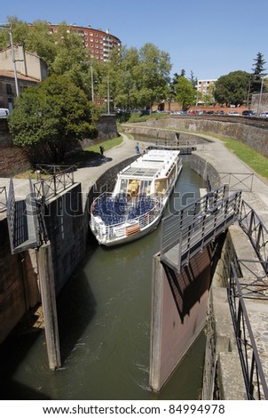 Canal du Midi and sightseeing boat at Toulouse, France. The Canal is a long waterway in Southern France, Connects the Garonne River to the Mediterranean and Atlantic. It was Protected by UNESCO.