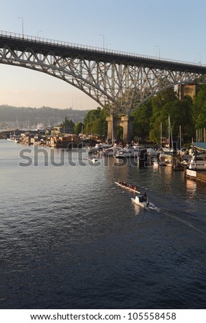 Lake Union Rowing Practice, Seattle, Washington. A rowing team practices in the ship canal heading under the Aurora Bridge for Lake Union. Seattle, Washington State, USA. .