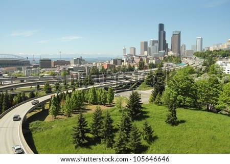 Seattle Skyline and Freeways. Downtown Seattle skyline with freeways foreground and Elliott Bay background. The mountains of the Olympic peninsula are visible in the distance. Washington State, USA.
