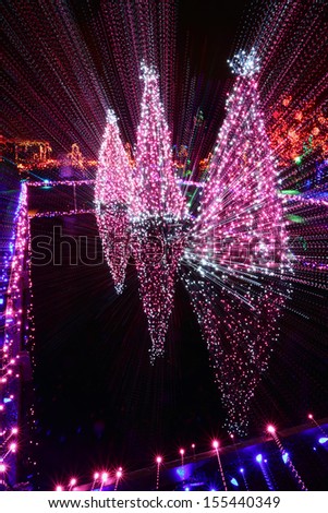 Christmas Light Streaks. Christmas lights and a fountain reflect in a pond. Streaks of light from a camera zoom and slow shutter.