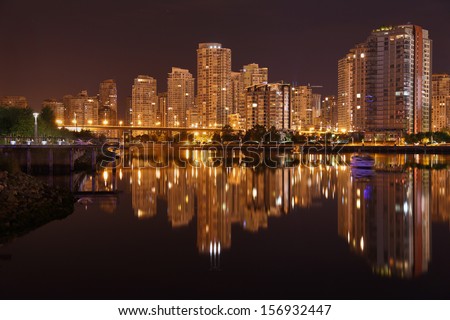 Night Skyline, Vancouver, British Columbia. Condominiums reflect in the calm waters of False Creek at night. Vancouver, British Columbia, Canada.