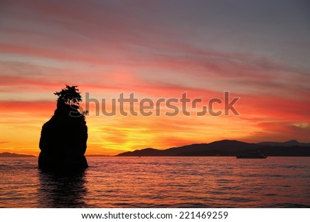 Siwash Rock Sunset, English Bay, Vancouver. Sunset over English Bay silhouetting Siwash Rock in Stanley Park. Vancouver, British Columbia, Canada.