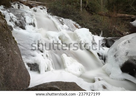 Mountain Falls, Winter Ice. Long exposure of a mountain stream waterfall with ice and snow. Motion blur.