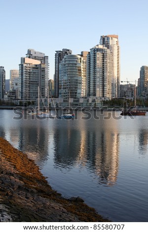 The morning light on the apartment buildings and condominiums of Vancouver\'s Yaletown neighbourhood reflect in False Creek. British Columbia, Canada.