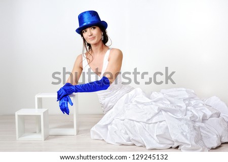 Bride in the studio in a blue hat and gloves