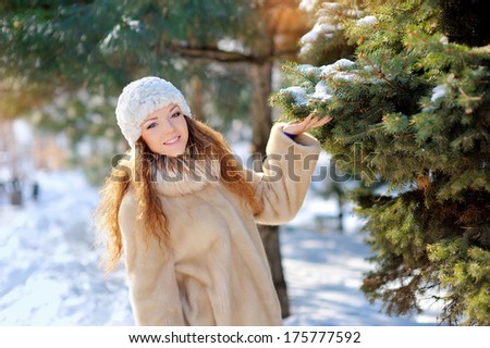 pretty girl on the street near the Christmas tree in winter