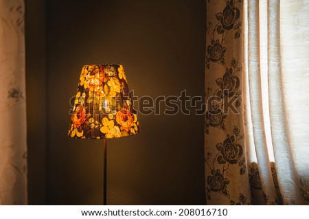 vintage Bedroom floor lamp glowing orange in a corner of a room