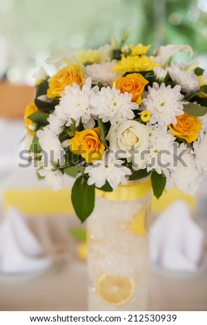 Bouquet of orange roses in a white wicker basket and vintage birdcage in the background